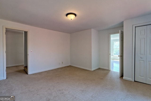 unfurnished bedroom featuring carpet floors, baseboards, and a closet