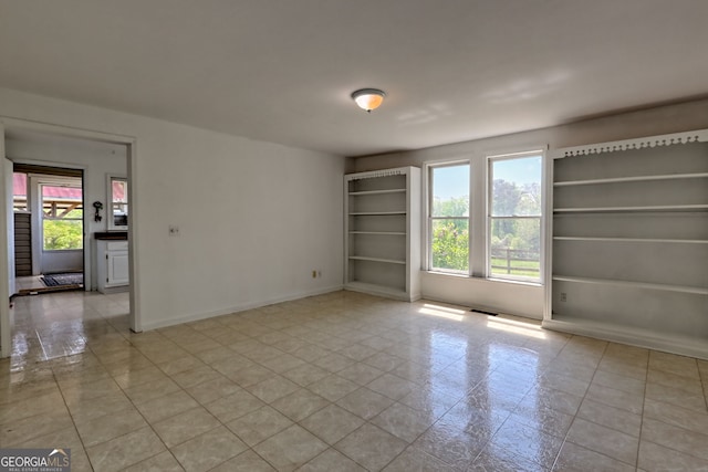empty room featuring plenty of natural light and baseboards