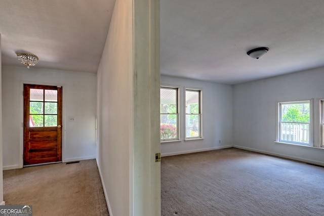 entryway with baseboards, plenty of natural light, and carpet flooring