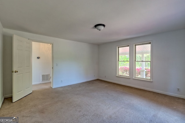carpeted empty room with visible vents and baseboards