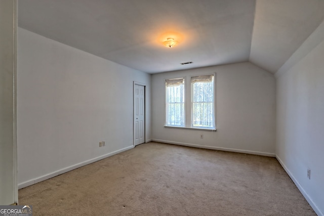 interior space featuring baseboards, carpet, and vaulted ceiling