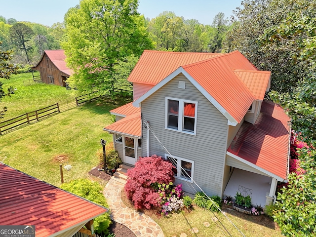 view of home's exterior with a lawn, fence, and metal roof