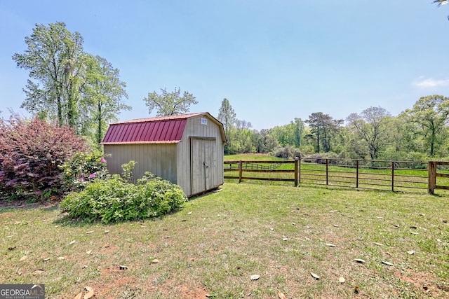 view of yard with an outdoor structure, fence, and a storage shed