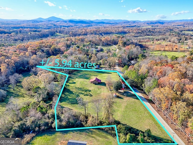 aerial view with a wooded view and a mountain view