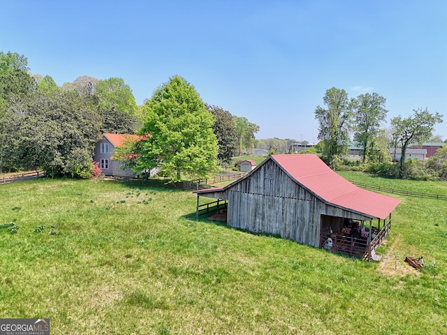 view of yard featuring fence, an outdoor structure, and an outbuilding