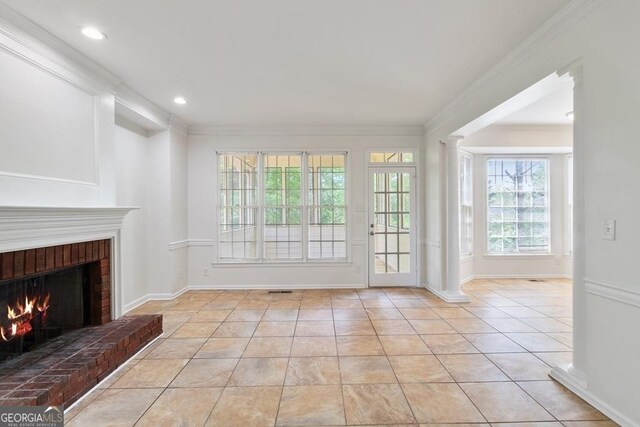 1720 Greystone Trce SE, Conyers, GA 30013 - unfurnished living room featuring a brick fireplace, light tile patterned floors, ornamental molding, decorative columns, and baseboards
