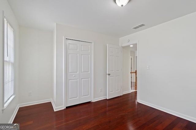 1720 Greystone Trce SE, Conyers, GA 30013 - unfurnished bedroom with wood finished floors, multiple windows, baseboards, and a closet