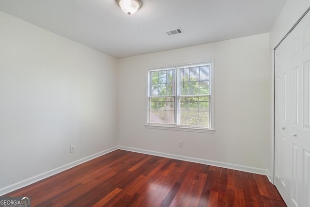 1720 Greystone Trce SE, Conyers, GA 30013 - unfurnished bedroom with a closet, dark wood-type flooring, and baseboards