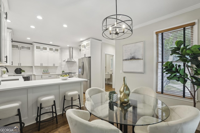 dining room with recessed lighting, crown molding, dark wood-style floors, and an inviting chandelier