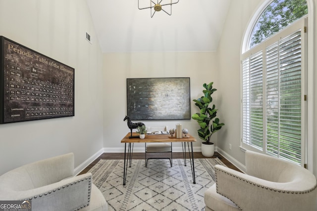 home office featuring baseboards, vaulted ceiling, wood finished floors, and visible vents