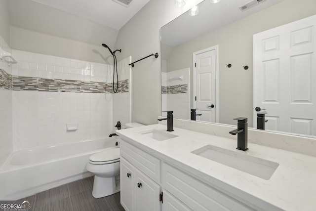 bathroom with a sink, bathing tub / shower combination, toilet, and visible vents