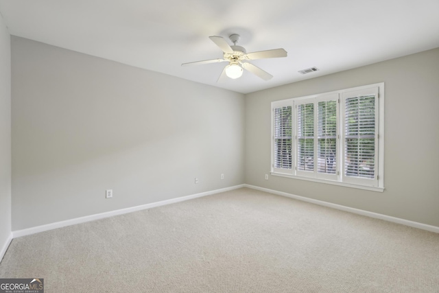 carpeted empty room featuring a ceiling fan, baseboards, and visible vents
