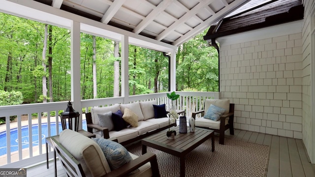 sunroom / solarium featuring an outdoor living space and beam ceiling