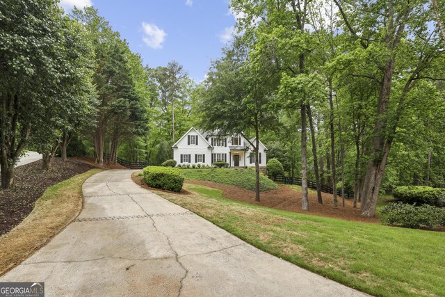 view of property exterior with a garage, a shingled roof, fence, and driveway