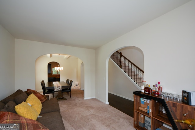 6816 Diamond Dr, Rex, GA 30273 - living room with arched walkways, carpet floors, stairs, a chandelier, and baseboards