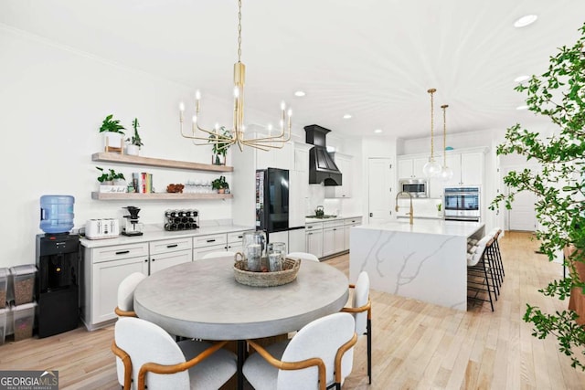 dining room with a chandelier, recessed lighting, and light wood finished floors