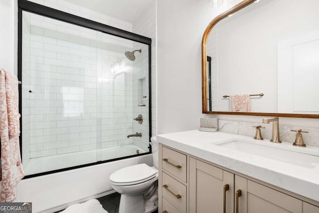full bath featuring vanity, toilet, and bath / shower combo with glass door