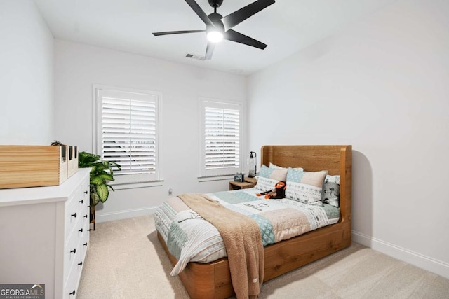 bedroom featuring light colored carpet, baseboards, and ceiling fan
