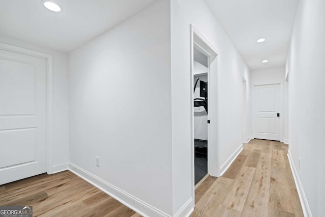 hall featuring light wood-style flooring, recessed lighting, and baseboards