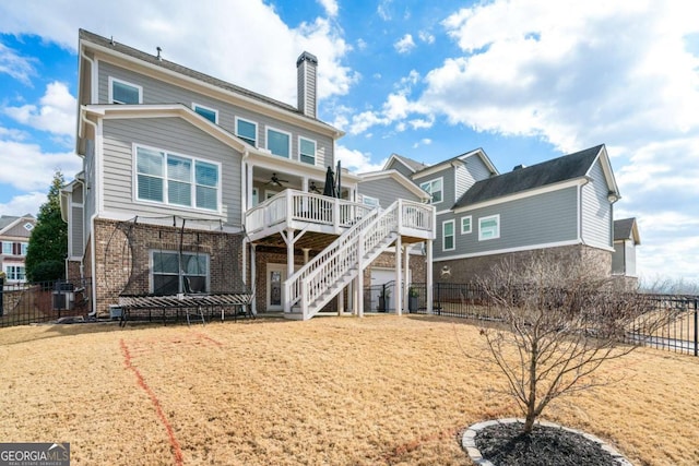rear view of property featuring ceiling fan, a chimney, stairs, a deck, and brick siding