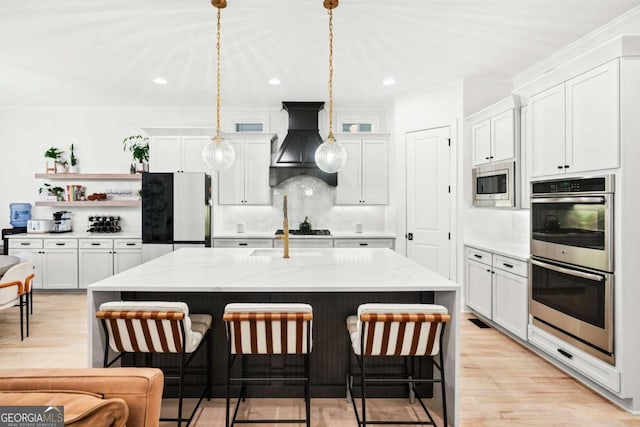 kitchen featuring stainless steel appliances, custom range hood, white cabinetry, backsplash, and open shelves
