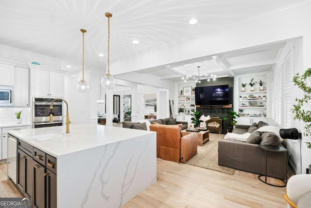 kitchen featuring appliances with stainless steel finishes, a chandelier, light wood-style floors, recessed lighting, and crown molding