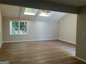 470 Ovara Ct, Stone Mountain, GA 30088 - bonus room featuring lofted ceiling with skylight, a ceiling fan, wood finished floors, and baseboards