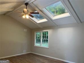 470 Ovara Ct, Stone Mountain, GA 30088 - bonus room with a ceiling fan, vaulted ceiling with skylight, wood finished floors, and baseboards