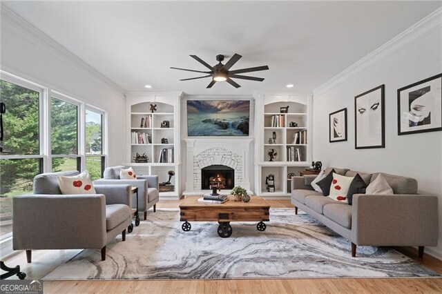 4030 Scenic View Ct, Cumming, GA 30028 - living area featuring ceiling fan, a lit fireplace, ornamental molding, wood finished floors, and built in shelves