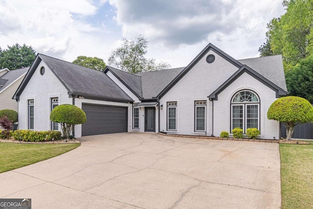220 Chandler Ct, Sugar Hill, GA 30518 - view of front of home featuring brick siding, concrete driveway, a garage, and a front yard