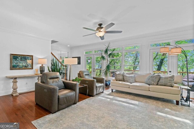 living room with baseboards, wood finished floors, a ceiling fan, and crown molding