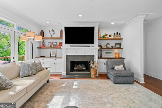 living area featuring baseboards, recessed lighting, ornamental molding, a fireplace, and wood finished floors