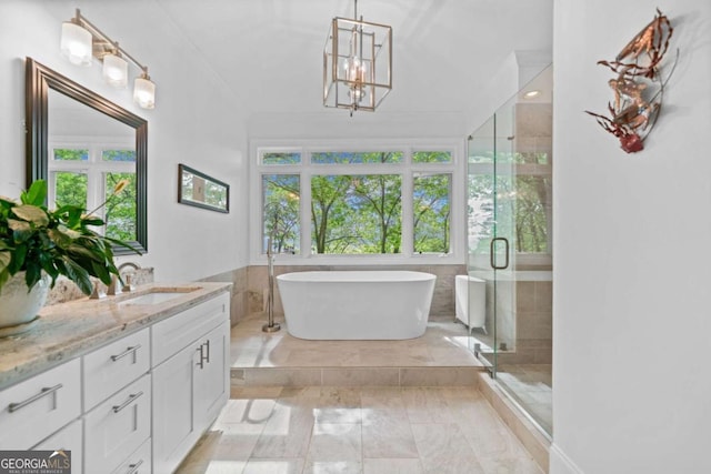 bathroom featuring a soaking tub, a stall shower, vanity, a notable chandelier, and marble finish floor