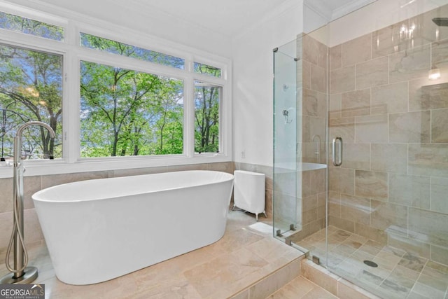 full bathroom with ornamental molding, a freestanding tub, tile walls, and a shower stall