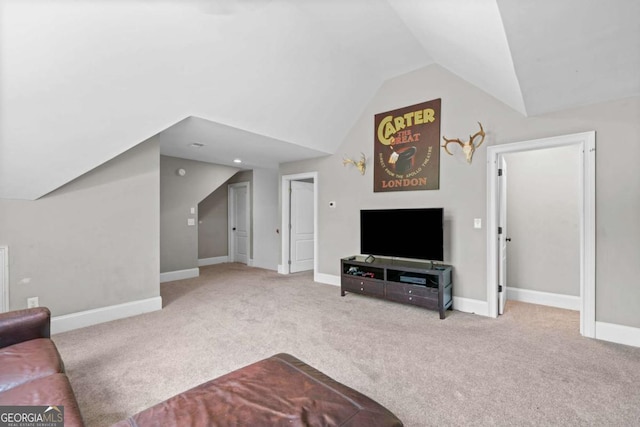 living room featuring vaulted ceiling, carpet floors, and baseboards