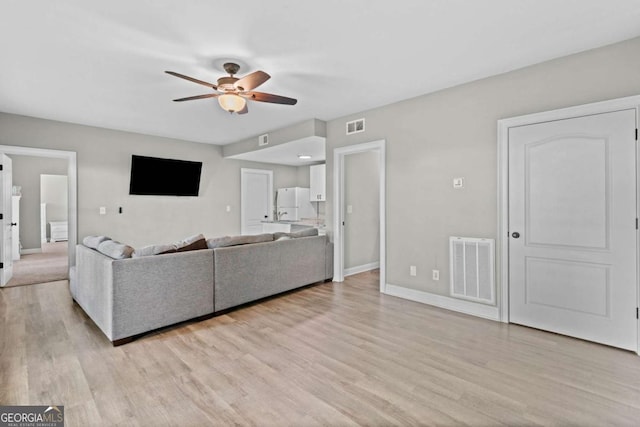 living room featuring visible vents, a ceiling fan, and light wood-style flooring
