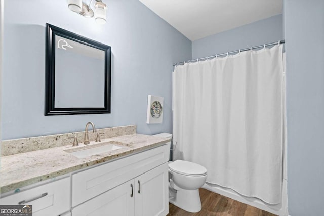 full bath featuring toilet, vanity, wood finished floors, and a shower with shower curtain