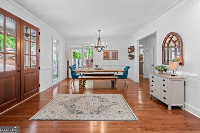dining room featuring a chandelier, french doors, hardwood / wood-style flooring, and crown molding