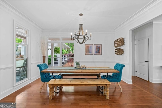 dining room with an inviting chandelier, wood finished floors, and ornamental molding