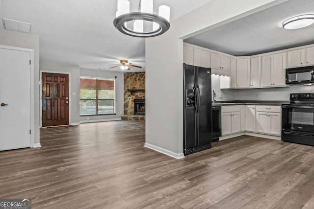108 Ashwood Pt Unit 196, Eatonton, GA 31024 - kitchen with black appliances, dark countertops, wood finished floors, white cabinets, and ceiling fan