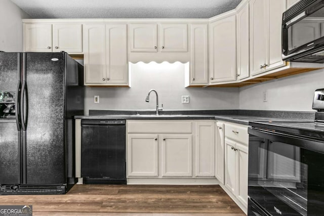 108 Ashwood Pt Unit 196, Eatonton, GA 31024 - kitchen with black appliances, dark countertops, dark wood-style floors, and white cabinetry