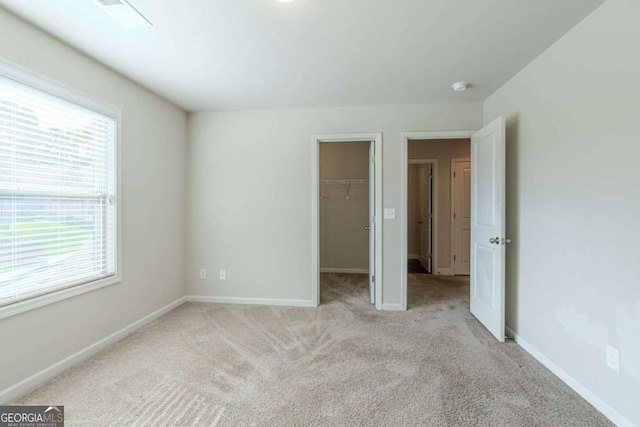 392 Dublin Way, Dallas, GA 30132 - unfurnished bedroom with baseboards, a spacious closet, multiple windows, and carpet