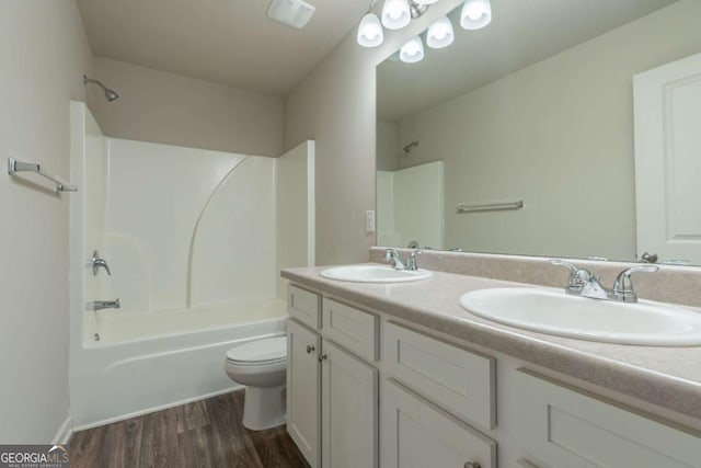 392 Dublin Way, Dallas, GA 30132 - full bathroom with washtub / shower combination, toilet, wood finished floors, and a sink
