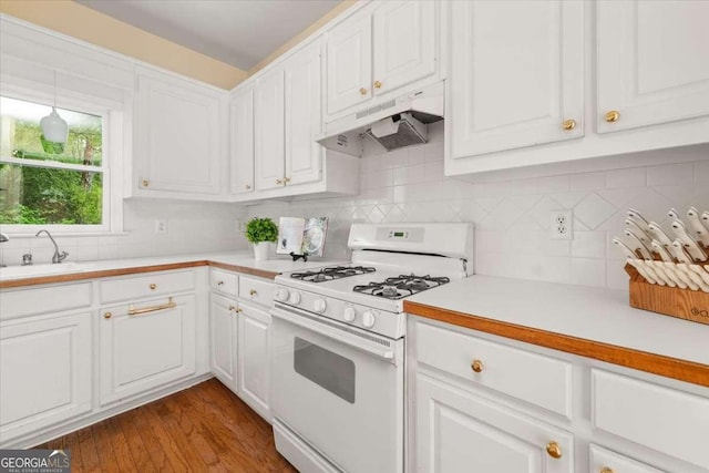 kitchen with a sink, white gas range oven, under cabinet range hood, light countertops, and white cabinets