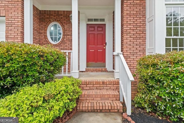 entrance to property with covered porch and brick siding