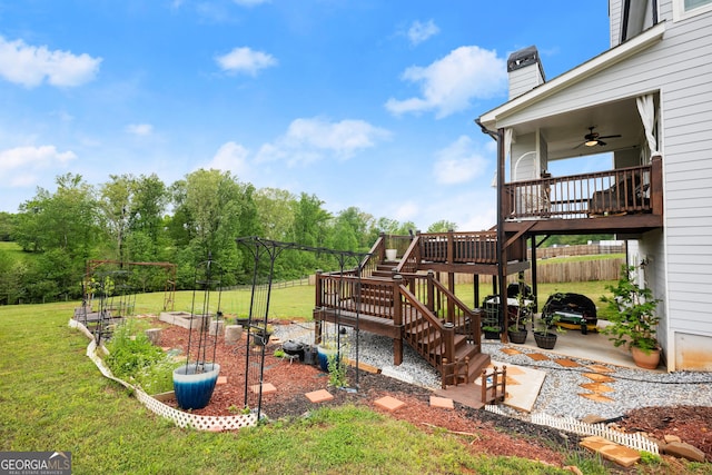 view of yard with a patio, a garden, fence, stairway, and a ceiling fan