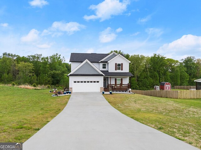 view of front of home featuring a porch, a storage unit, fence, driveway, and a front lawn