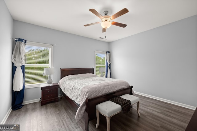 bedroom featuring wood finished floors, ceiling fan, visible vents, and baseboards