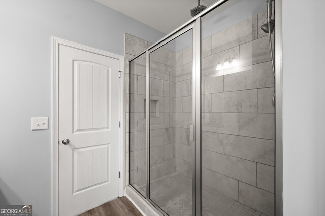 full bath featuring wood finished floors and a stall shower