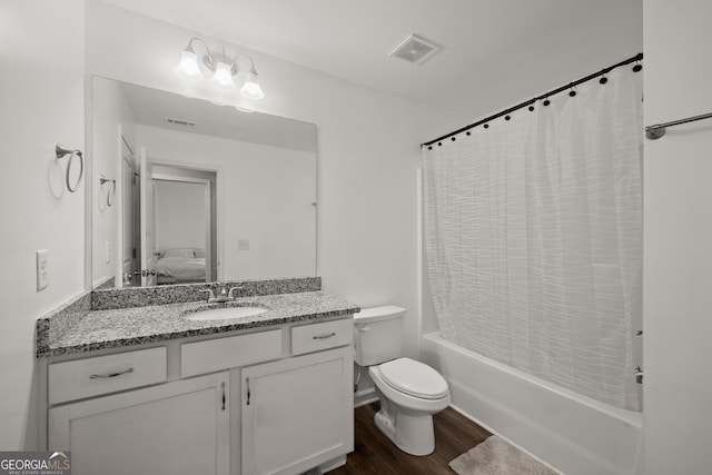 ensuite bathroom featuring wood finished floors, toilet, vanity, visible vents, and shower / tub combo with curtain